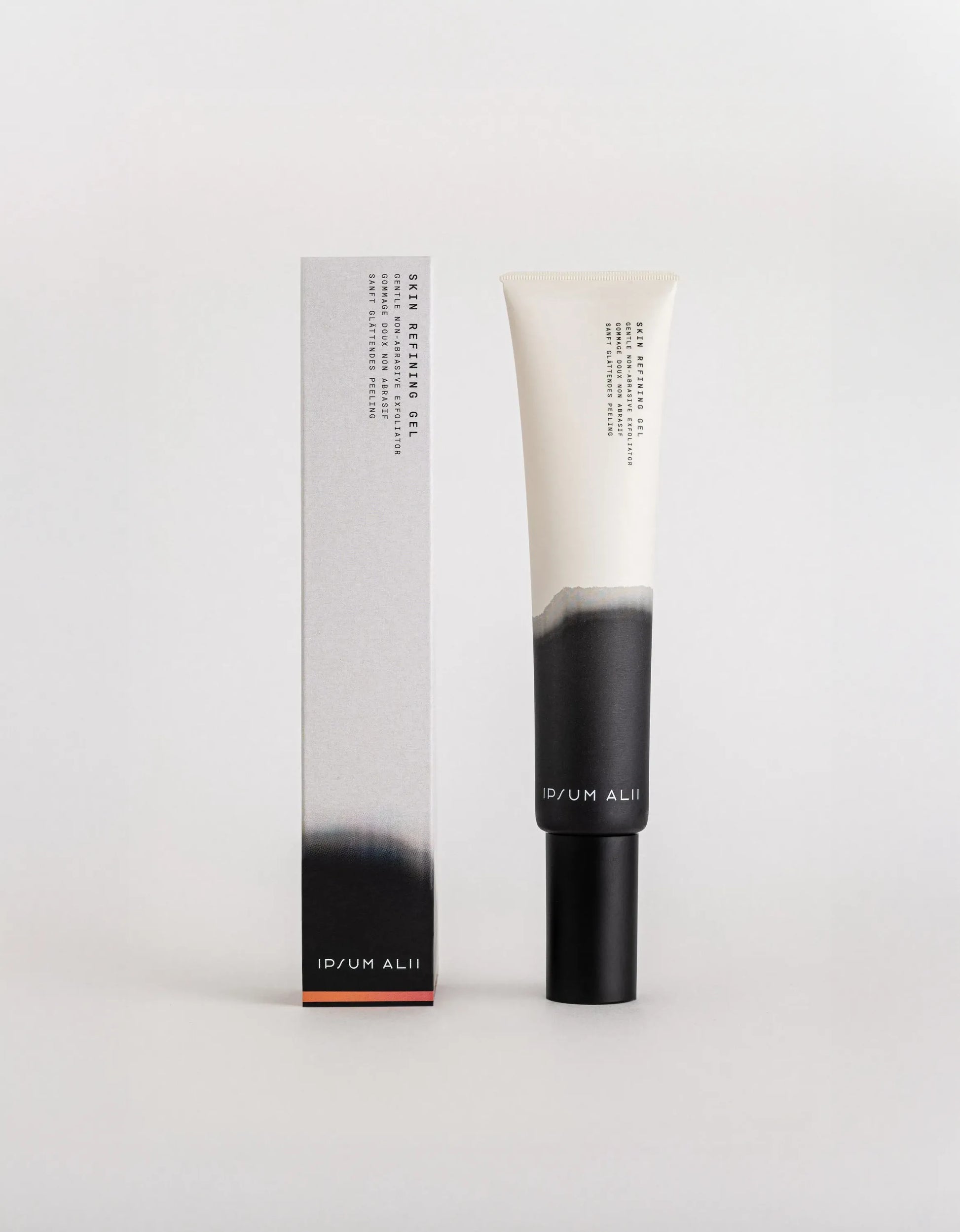 A tube of Ipsum Ali Skin Refining Gel standing next to its box against a plain light background. Both the tube and box feature a white and black gradient design with a black cap and minimal text.