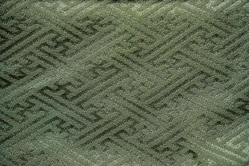 A piece of kimono fabric featuring an intricate, woven geometric pattern in varying shades of green.