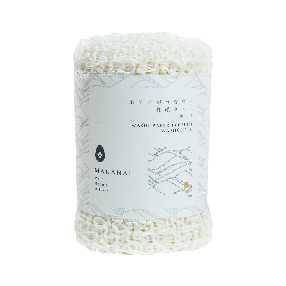 A rolled white Makanai Washi Paper Perfect Washcloth wrapped with a minimalist white paper label. The label includes Japanese and English text along with simple wave-pattern graphics.