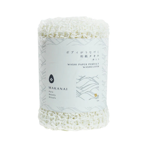 A rolled white Makanai Washi Paper Perfect Washcloth wrapped with a minimalist white paper label. The label includes Japanese and English text along with simple wave-pattern graphics.