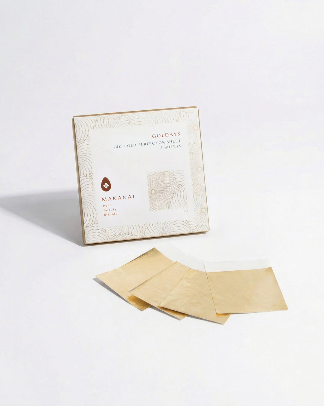 A white box labeled “Makanai Goldays 24K Gold Perfector Sheet” stands on a light background with four thin gold sheets laid out in front of it.